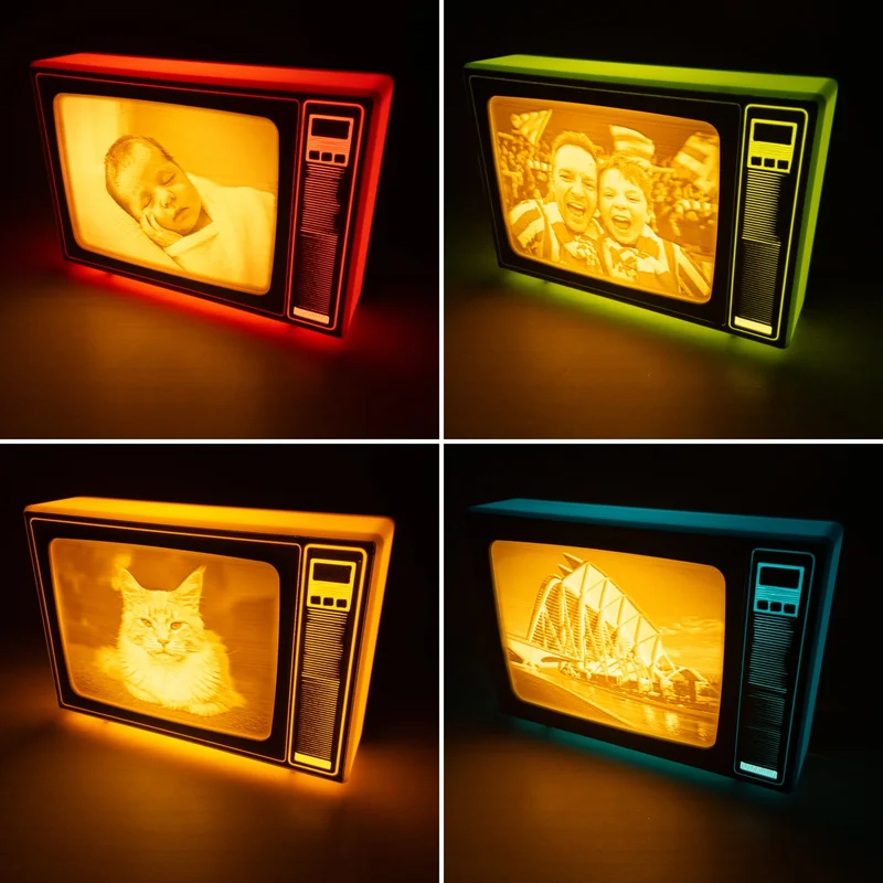 Four Brilla retro TVs switched on in the dark, in pink, green, yellow and blue, each showing a photo on its glowing screen: a sleeping baby, two cheering fans, a cat and a modern building